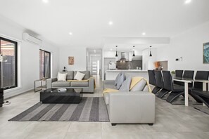 Relax in this stylish living space with a sofa, dining table, and modern kitchen.