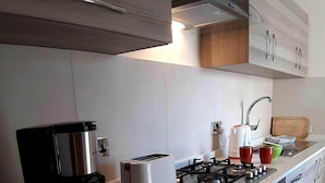 Cozinha moderna com fogão a gás, cafeteira e torradeira.