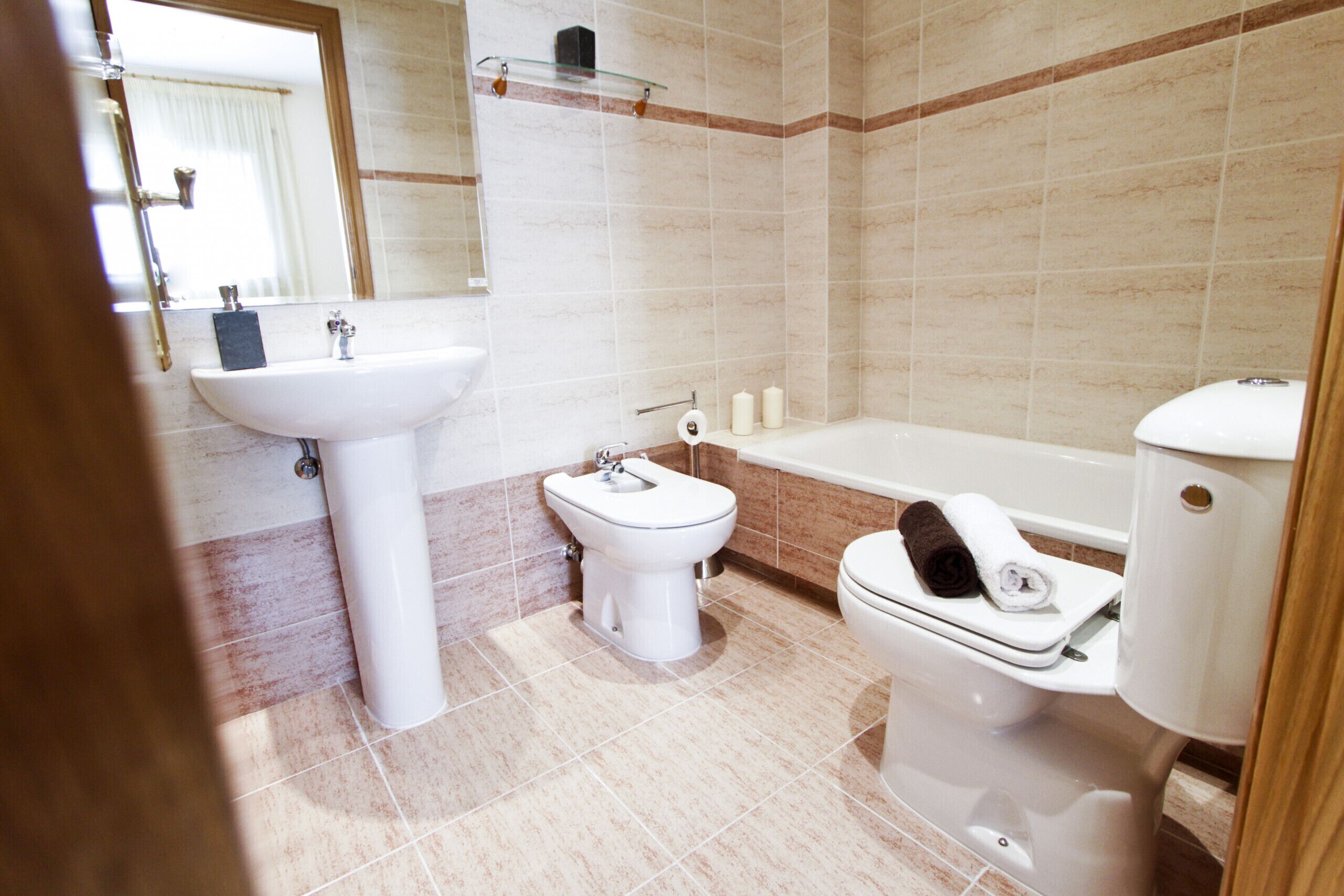 Une salle de bain équipée d’un lavabo, de toilettes, d’un bidet et d’une baignoire.