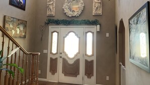 A staircase with a wooden handrail, a world map, and decorative wall art including cherubs and a wreath. - Nice secluded home with plenty of room to roam! (Kanab)