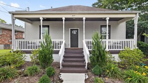 A two-story house with a front porch, a front door, and a number '827' on the house.