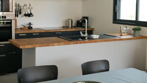 Une cuisine moderne avec un plan de travail en bois, des armoires noires et une fenêtre.