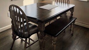 Comedor con una mesa grande, sillas y vistas a un paisaje montañoso a través de las ventanas.