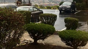A parking area with two cars, a fence, and a view of a cityscape in the background. - ❤️ 🏙 The View-Stylish Interior- Min to downtwn 🌃 ❤️ (Cincinnati)