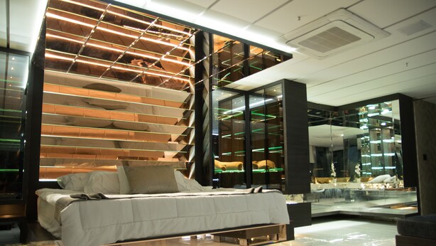 A modern bedroom with a bed, a glass wall, and a reflective floor. - Stunning Golden Marble Suite Parque Lleras (Medellín)