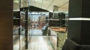 A modern kitchen with a marble countertop, a built-in oven, and a glass partition. - Stunning Golden Marble Suite Parque Lleras (Medellín)