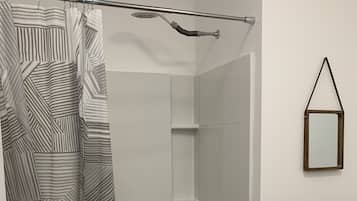 Bathtub, hair dryer, towels, toilet paper