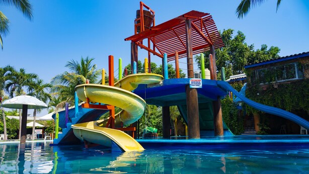 Um parque aquático com vários toboáguas e uma piscina.