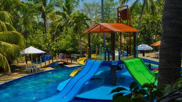 A water park with multiple slides and a pool area surrounded by palm trees.