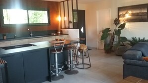 Une cuisine moderne dotée d’un îlot central, de tabourets de bar et d’un coin repas.
