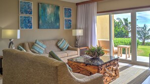 Un salon avec un canapé, une table basse et une vue sur un jardin, accessible par une porte-fenêtre coulissante.