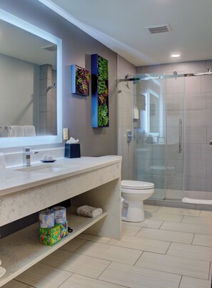 A modern bathroom with a marble sink, a large mirror, a glass shower enclosure, and a vertical garden. - Dawn Beach Club Resort Sint Maarten (Oyster Pond)