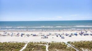Una playa con numerosos sombrillas y gente.