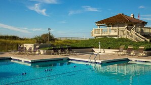 Una piscina amb gandules i un edifici amb un balcó al fons.