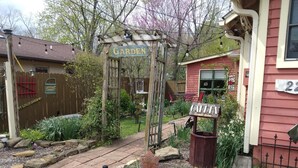 A garden entrance with a wooden archway, a guest suite sign, and a mailbox. - Betty Lou's Garden Guest Suite (Nashville)