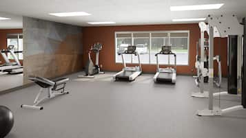 Ein Fitnessraum mit Laufbändern, einer Bankpresse und Gewichtsmaschinen.