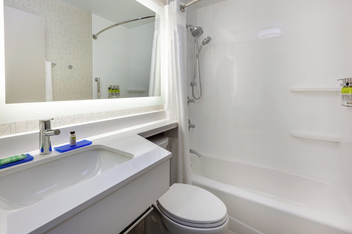 Une salle de bain moderne avec un lavabo blanc, un miroir et une baignoire.