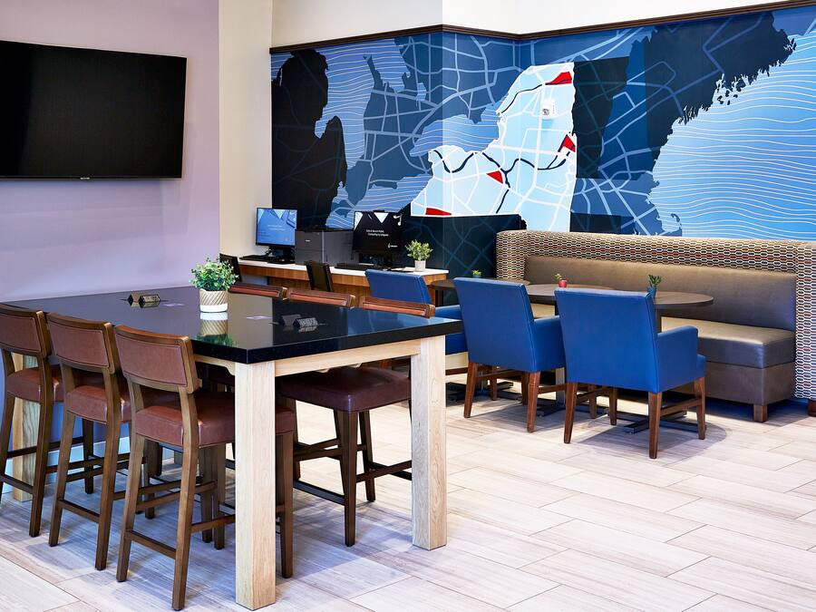Ein moderner Konferenzraum mit großem Tisch, Stühlen, einer Couch und einer großen Wandkarte.