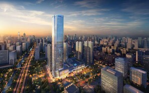 Un immeuble de grande hauteur doté d’une façade moderne en verre, entouré d’un paysage urbain dense, composé de nombreux autres immeubles de grande hauteur.