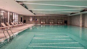 Una piscina con sillas de descanso y una escalera.