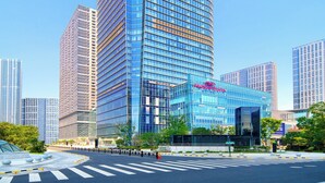Un edificio moderno de gran altura con fachada de vidrio y un letrero llamativo que dice 'GROWTH'.