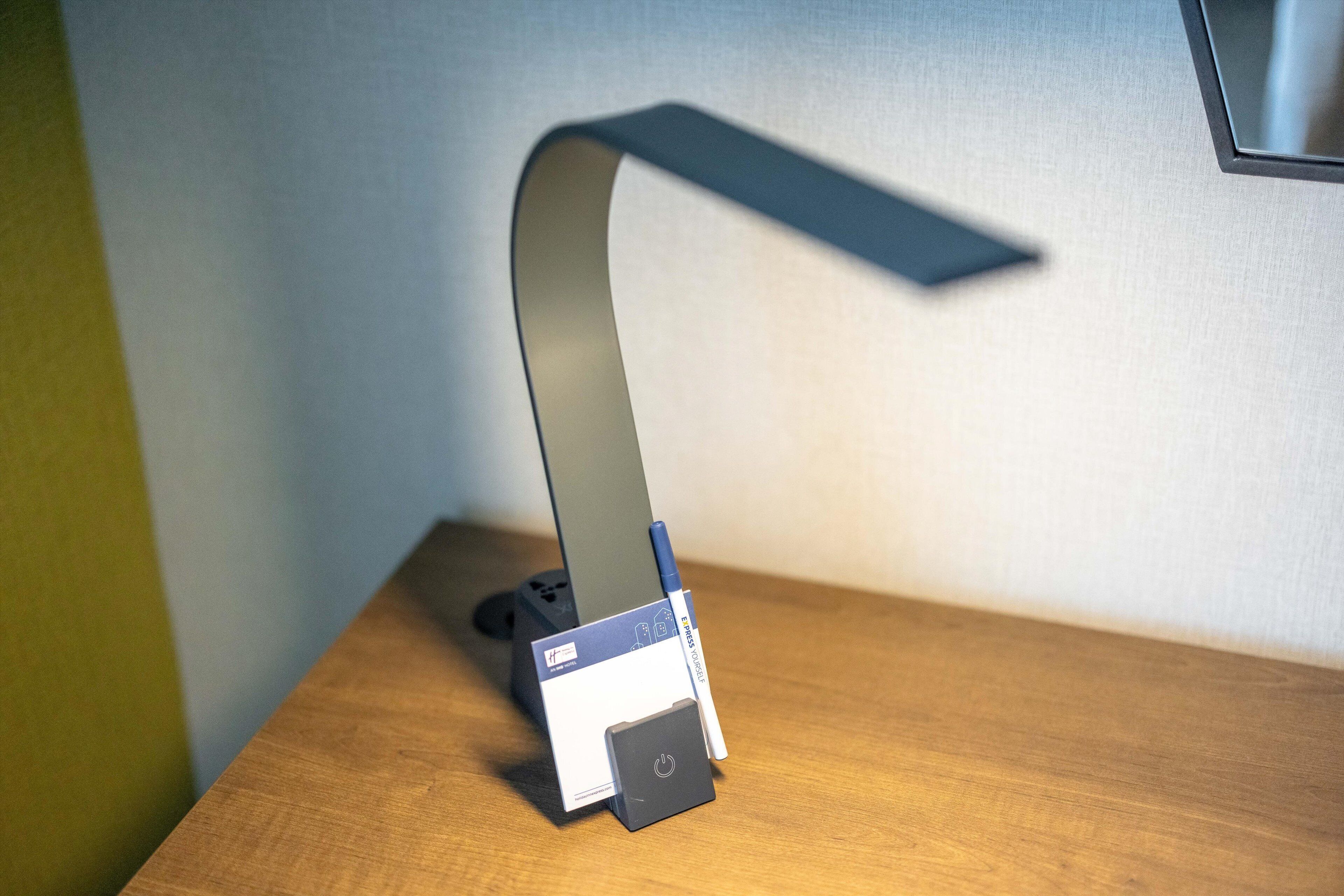 Ein Schreibtisch mit Lampe, Stift und einer Schachtel.