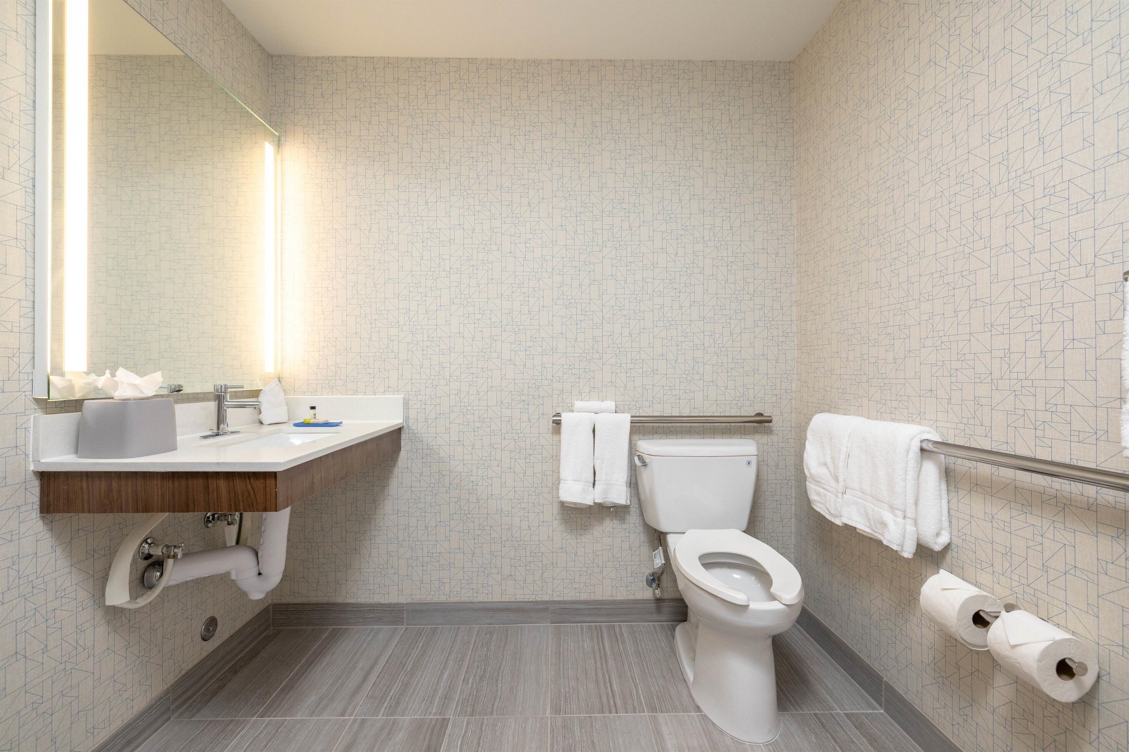 A modern bathroom with a toilet, sink, and towel rack.