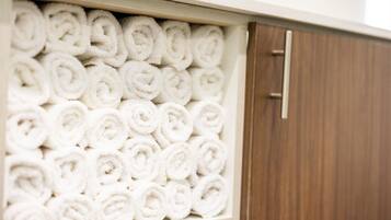 A storage unit filled with neatly rolled white towels.
