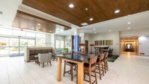 Un espace intérieur spacieux comprenant une grande table et des chaises, un canapé et un escalier menant à un autre niveau.