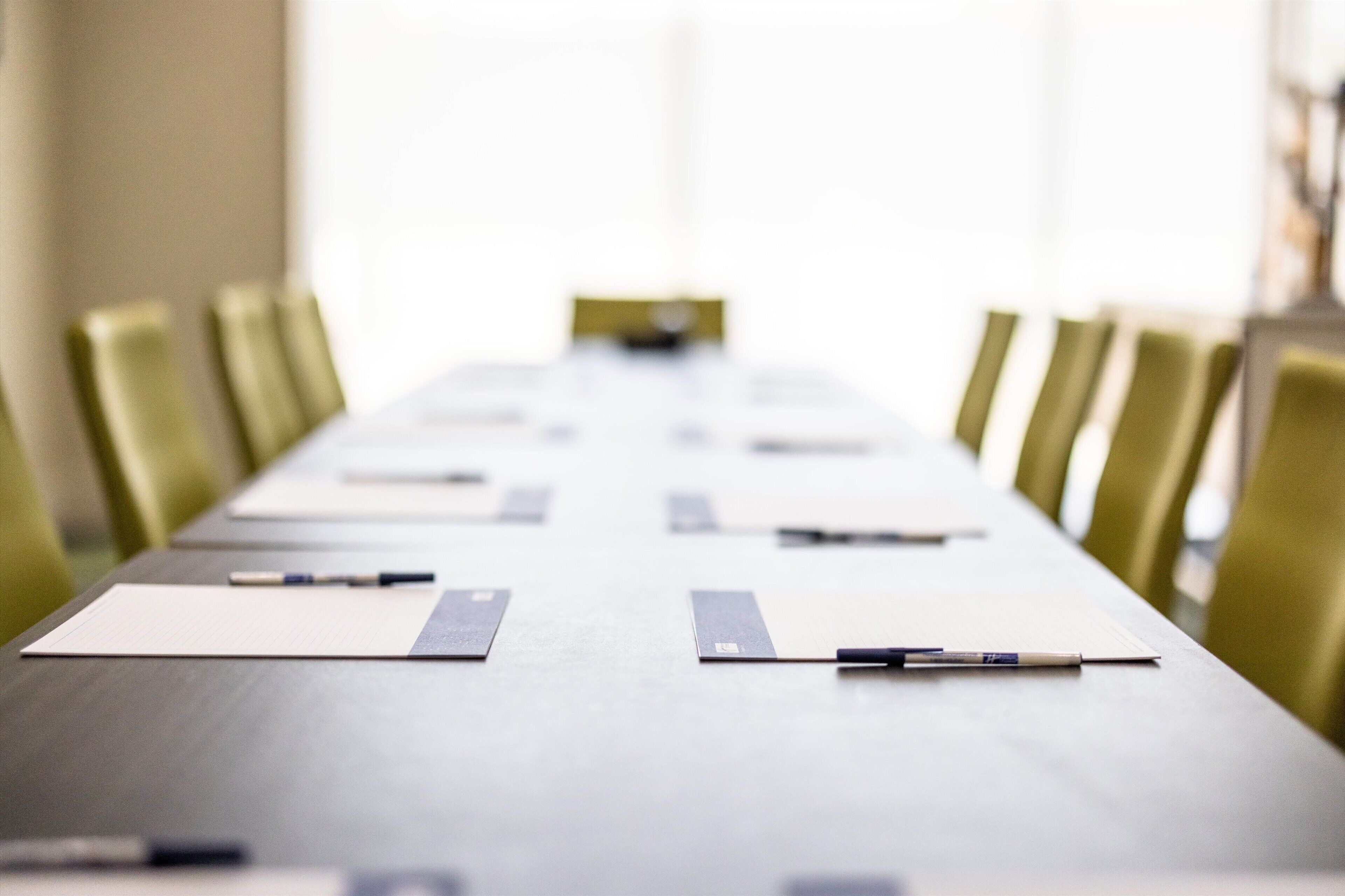 A conference room with a long table, chairs, and nameplates.