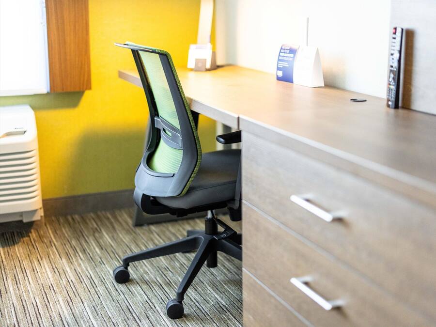 A modern office space with a desk, chair, and filing cabinet.