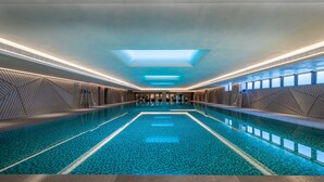 An indoor swimming pool with a geometric tiled floor, a skylight, and a modern architectural design. - Holiday Inn Xi an Chanba by IHG (Xi'an)