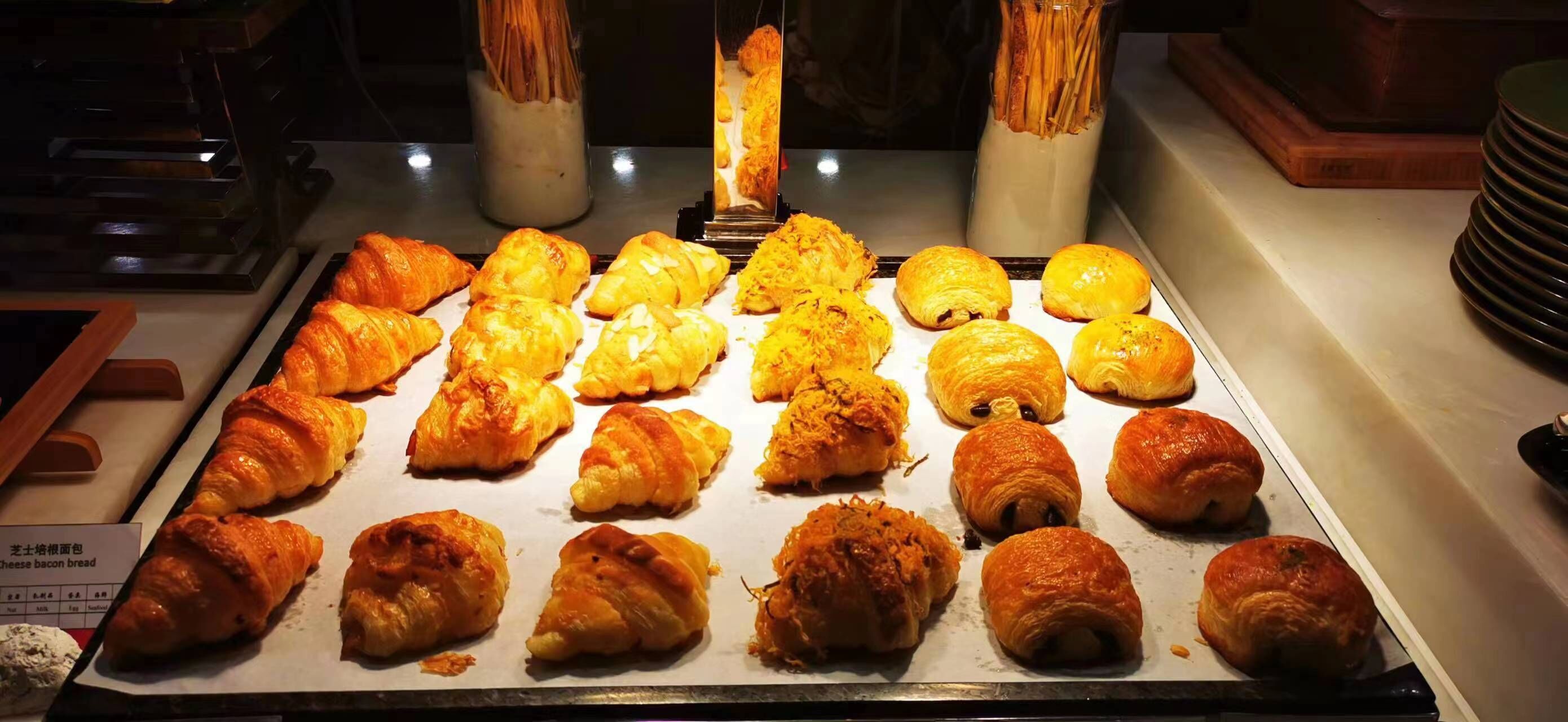 A display of assorted pastries, including croissants and other baked goods, arranged on a tray.