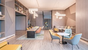 A modern interior with a dining area, seating, and a staircase. - Holiday Inn Xi an Chanba by IHG (Xi'an)