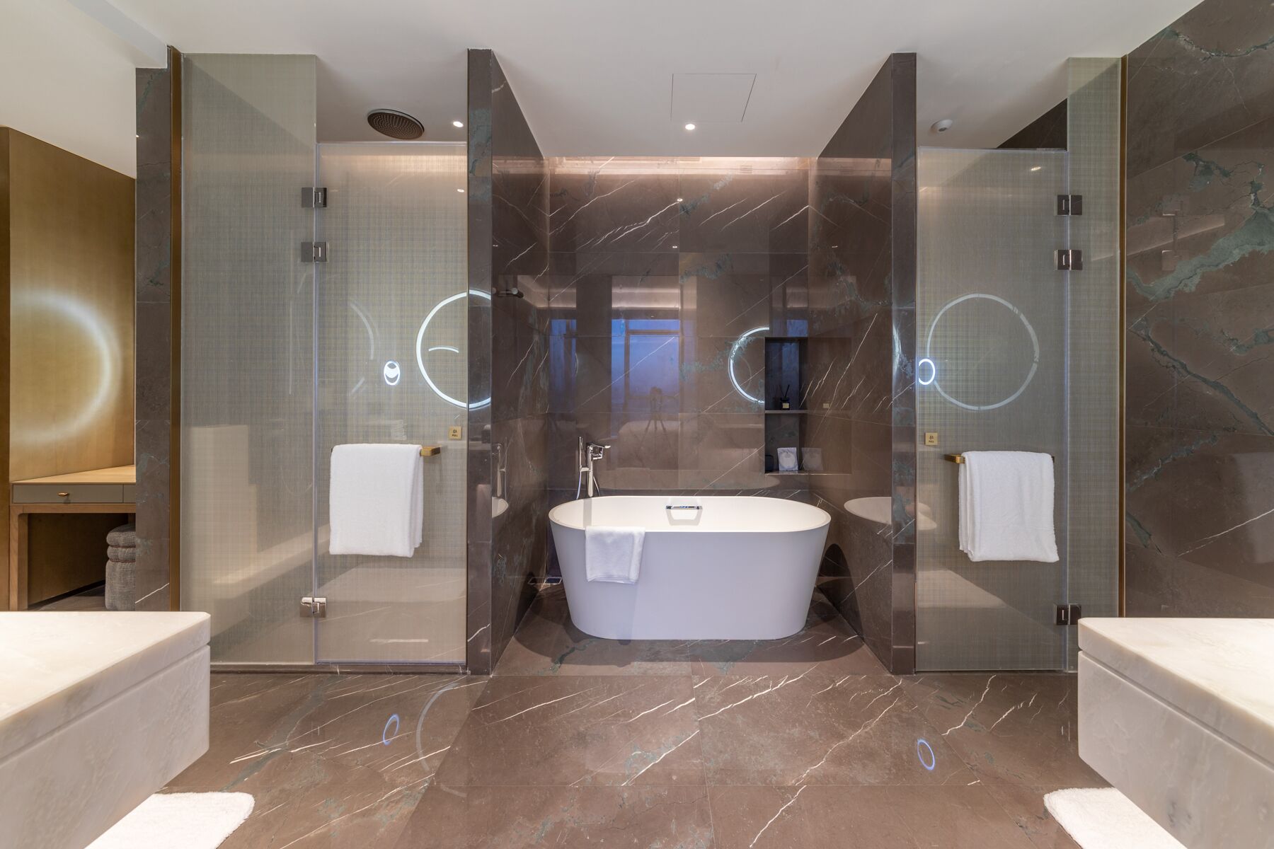 Une salle de bain moderne avec une baignoire sur pieds, deux vasques et des cabines de douche en verre.