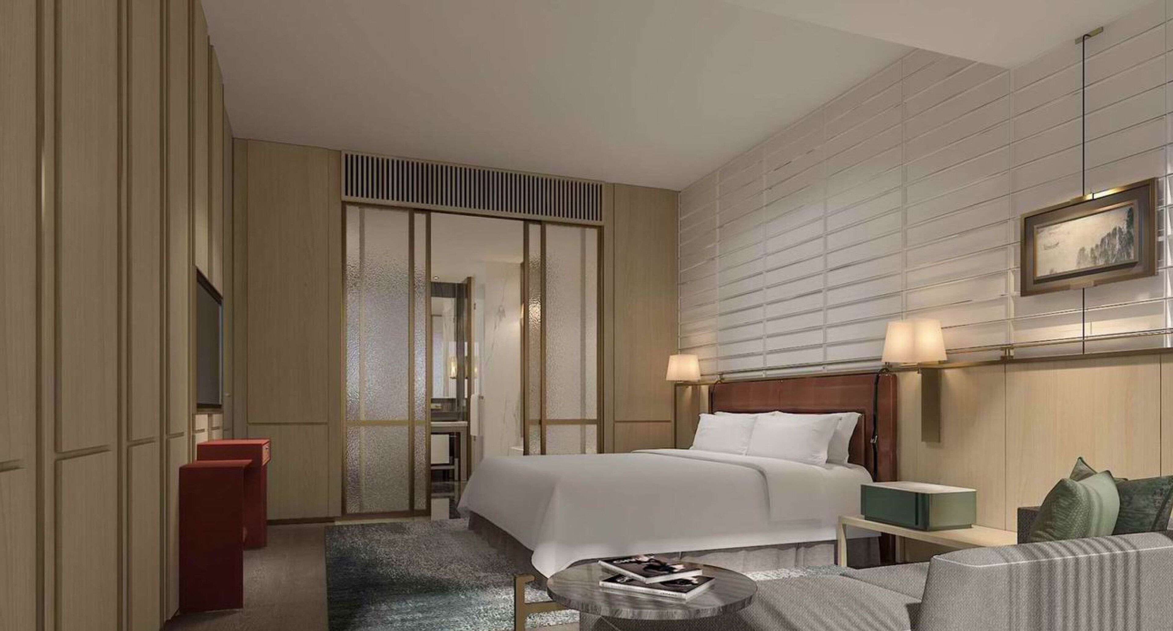 Una habitación de hotel con una cama, mesitas de noche, una pequeña mesa redonda y un sofá.