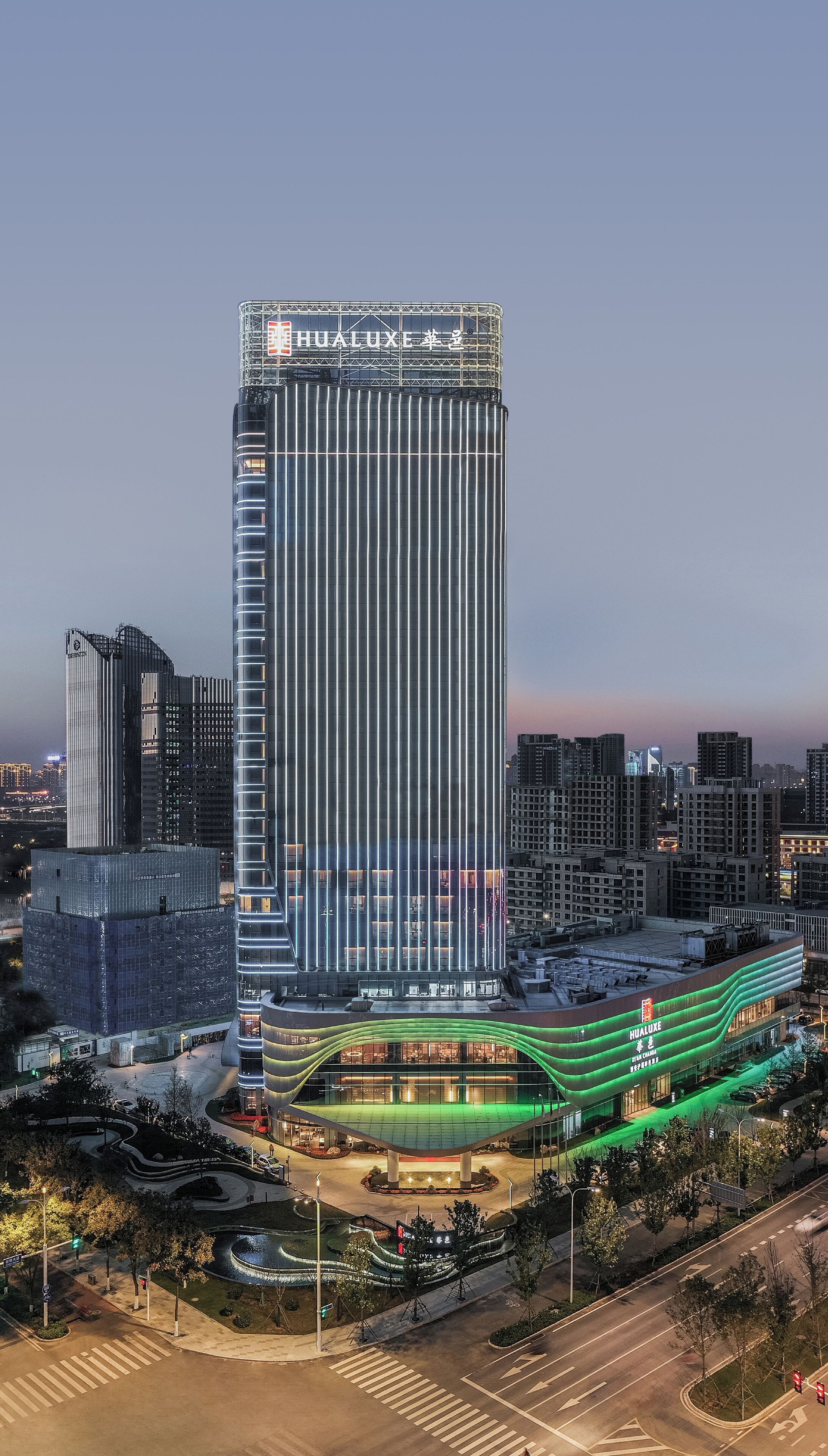A modern high-rise building with a prominent "HUALuxe" sign at the top.