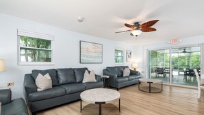 A modern living room with two sofas, a coffee table, and a ceiling fan. - Waterfront Private Home-7 BR, 6 Full BA, Pool, 80' Dock, Parking, Screened Porch (Marathon)