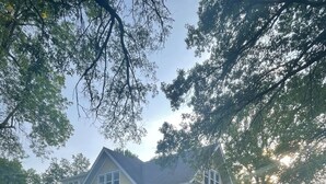 Een tweelaags huis met een veranda, een garage en een verzorgd gazon.