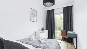 Una habitación de hotel moderna con cama, escritorio y silla.