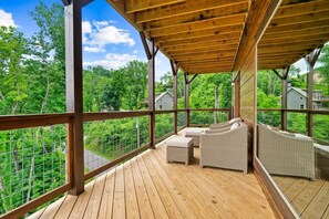 A wooden deck with wicker furniture and a view of a lush green landscape. - NEWLY BUILT Amazing View Chalet•Perfect Location (Gatlinburg)
