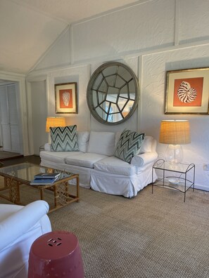 Relax in this stylish living room with a large mirror, two sofas, and a glass coffee table.