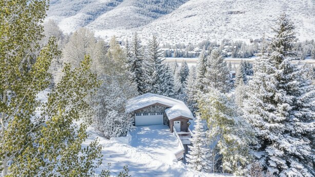 Paisatge de muntanya cobert de neu amb una cabana al primer pla.