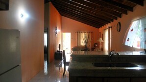 A kitchen with a stone countertop, a sink, and a wooden ceiling. - A cozy home in a quiet residential community  minutes from Town Central (Montego Bay)