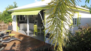 A house with a covered porch, a wooden deck, and outdoor seating.