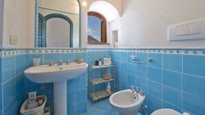 A bathroom with a sink, bidet, and mirror. - Sweet Home (Praiano)