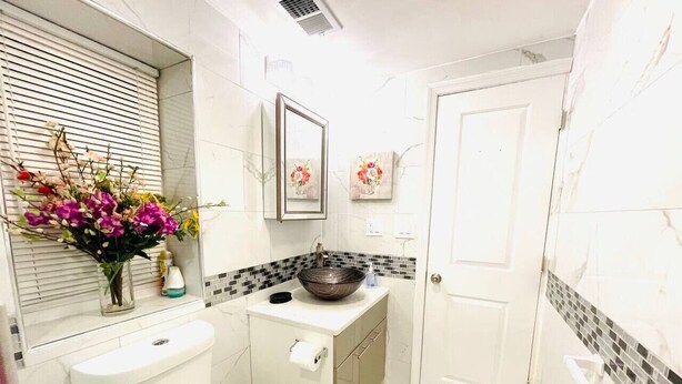Ein Badezimmer mit Toilette, Waschbecken und Spiegel.