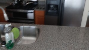 A kitchen with a stainless steel refrigerator, a microwave, and a stove.