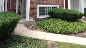 A two-story residential building with a brick facade, white trim, and a front porch.