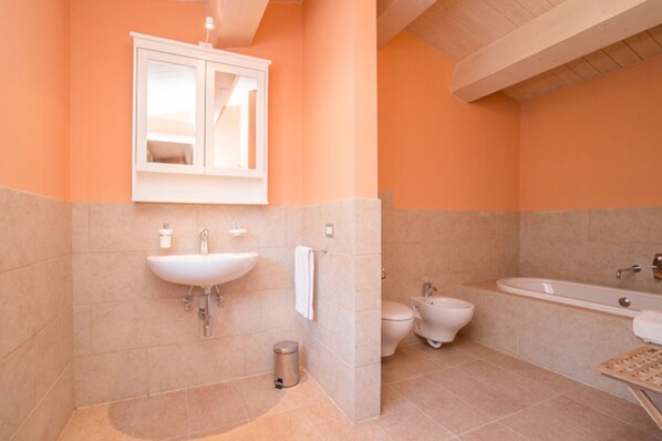 Een bad/douchecombinatie, een haardroger, een bidet, handdoeken